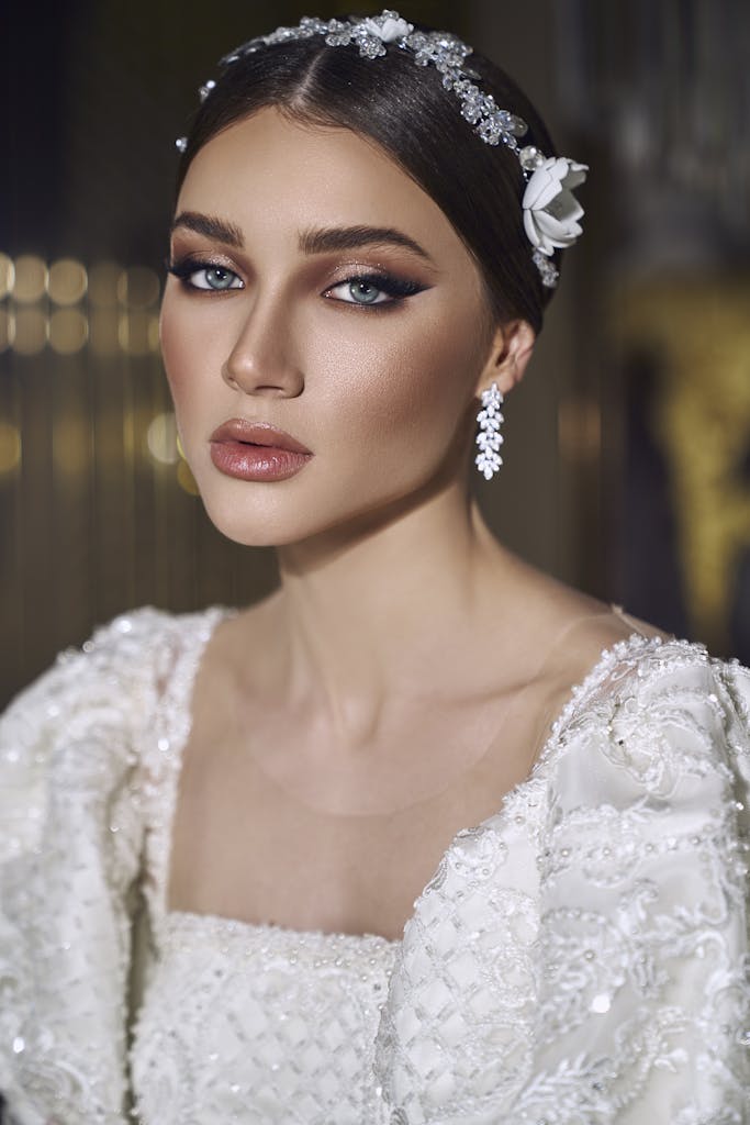 Close-up portrait of a bride with elegant makeup and crystal hairband in wedding attire.