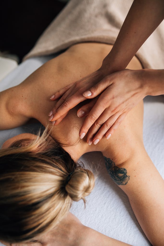 Female receiving a soothing massage in a tranquil spa environment, focusing on wellbeing.